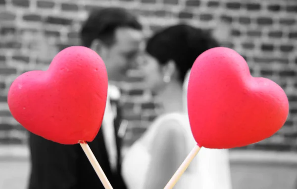 Recém Casados Turtelão Atrás Dois Corações Vermelhos — Fotografia de Stock