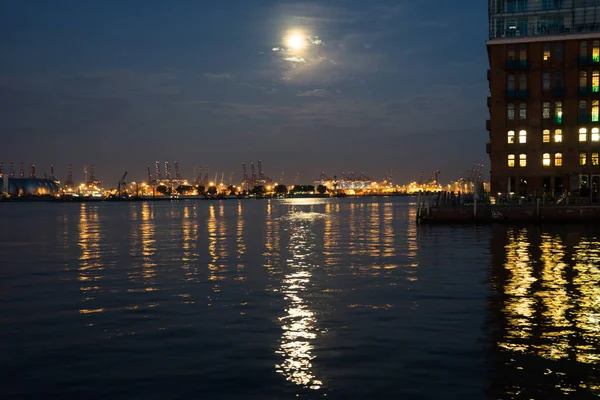 view of the port of hamburg at dawn with the moon setting