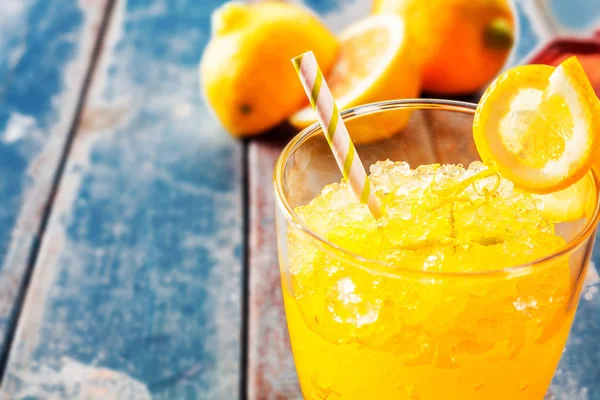 오렌지 쐐기를 오렌지 얼어붙은 음료수를 가까이 배경에는 오렌지가 피크닉 테이블에 — 스톡 사진
