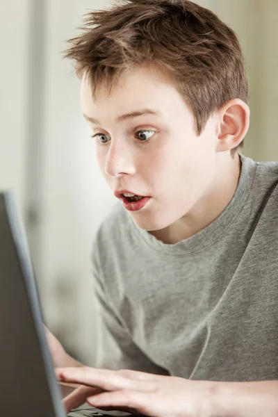 Yakışıklı Çocuk Şaşırtıcı Yüz Fadesi Ile Laptopunu Hazırlıyor — Stok fotoğraf