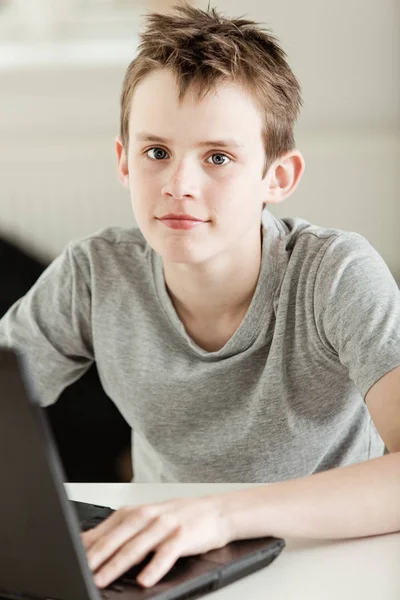 Masada Dizüstü Bilgisayarı Üzerinde Çalışırken Kameraya Bakan Yakışıklı Genç — Stok fotoğraf