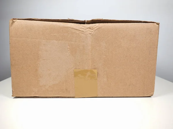 Small Brown Packet Corrugated Cardboard Parcel Mail Shipping White Table — Stock Photo, Image