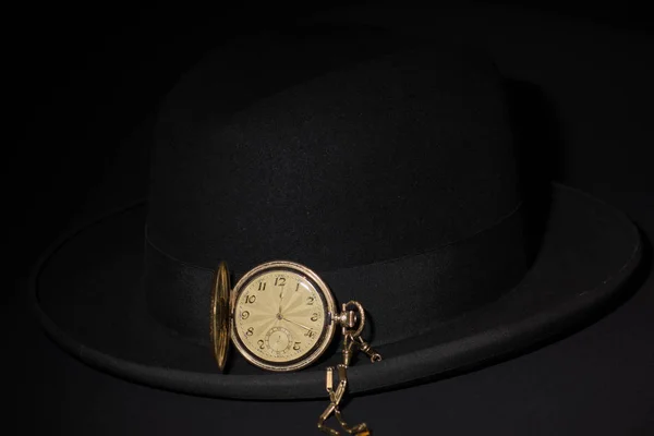 ブラック男性の帽子黒を背景に黄金のポケットウォッチ — ストック写真