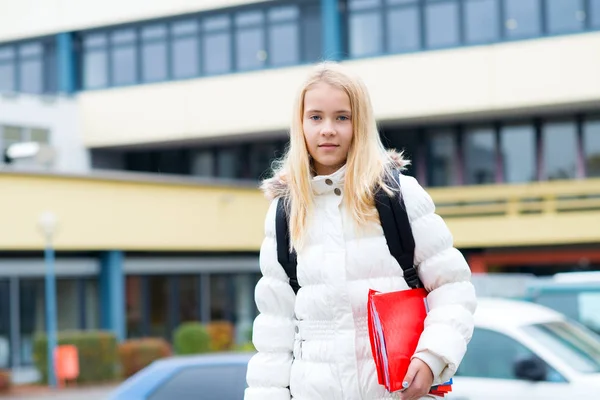 学校の建物の前にいる素敵なブロンドの女の子 — ストック写真