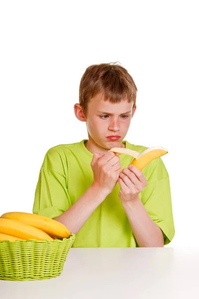 Young Boy Peeling Banana Expression Distaste Scowl Sits Table Basket — Stock Photo, Image