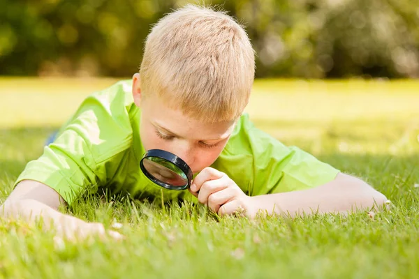 Criança Masculina Curiosa Cabelos Loiros Camisa Verde Deitada Grama Enquanto — Fotografia de Stock