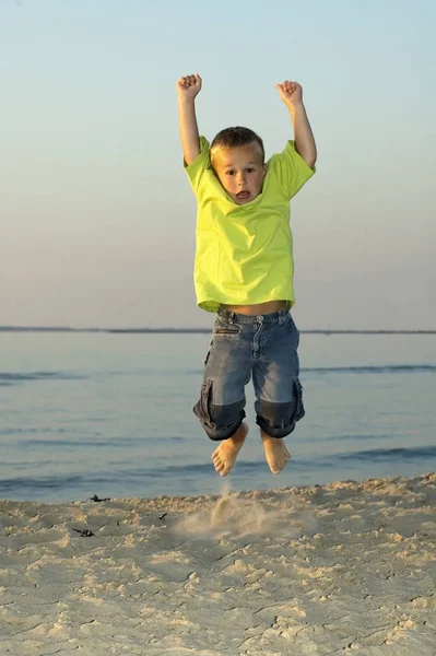 日没の間にビーチで少年をジャンプ — ストック写真