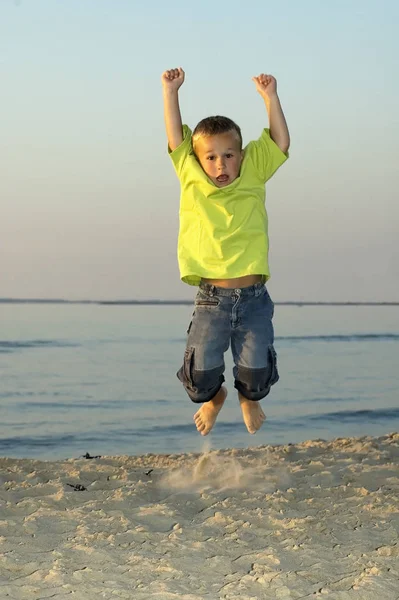 Saltando Ragazzo Una Spiaggia Durante Tramonto — Foto Stock