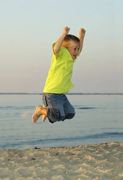 日没時にビーチで6歳のジャンプ — ストック写真