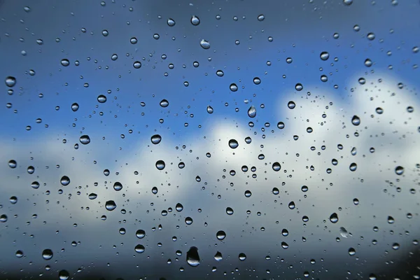 Regentropfen Auf Einer Fensterscheibe Vor Blauem Himmel Mit Wolken — Stockfoto