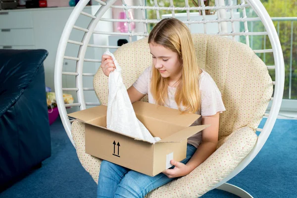 Blondes Mädchen Sitzt Stuhl Und Öffnet Ein Paket — Stockfoto