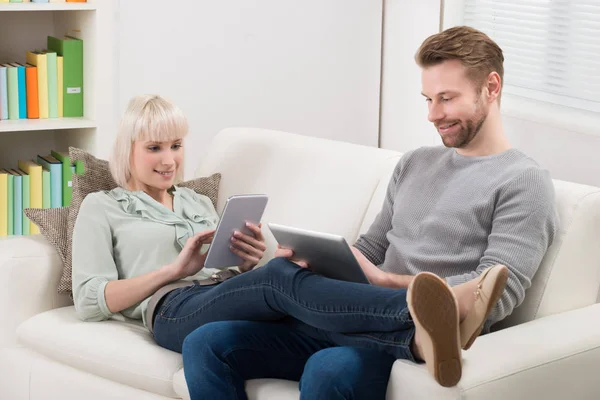 Jeune Couple Détendre Sur Canapé Utilisant Des Tablettes Numériques Maison — Photo