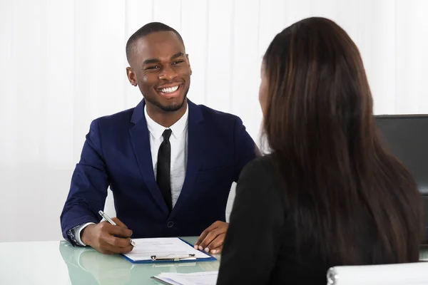 Male Manager Interviewing A Young Female Applicant In Office