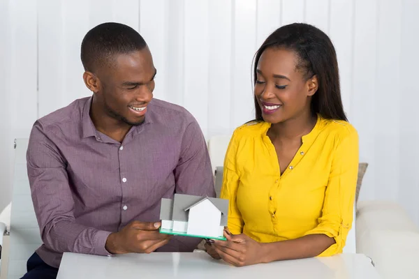 Jonge Gelukkige Afrikaanse Paar Houden Een House Model Thuis — Stockfoto
