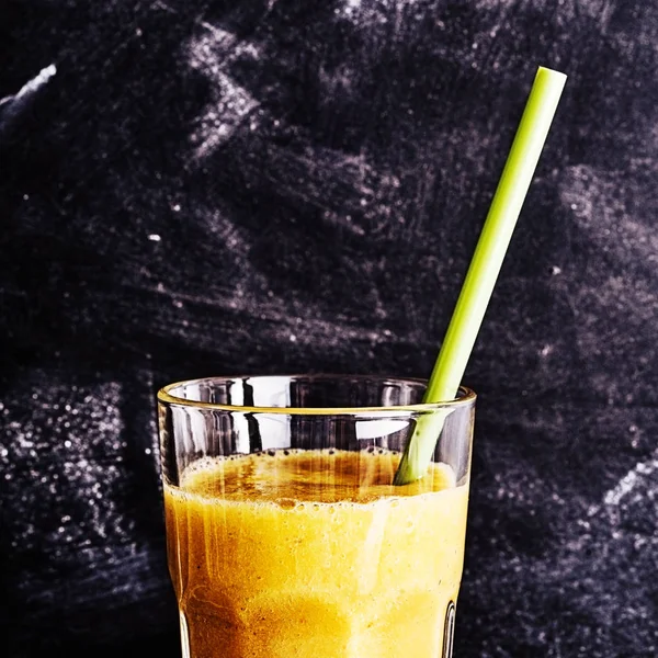黒の黒板を背景にしたグラスを飲みながら マンゴーの新鮮な風味のスムージーの上半分にクロップビュー — ストック写真