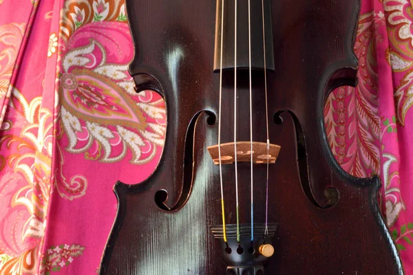 明るいピンクのペイズリーを背景にした古いバイオリン 1800年代初頭の暗い汚れ オリジナルの仕上げ からアンティークです — ストック写真