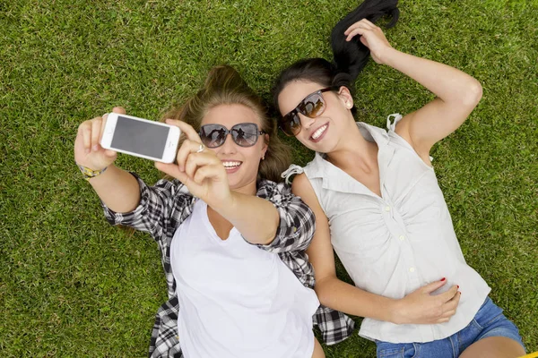 Iyi Kadın Arkadaşlar Çimenlerin Üzerinde Uzanıp Selfie Çekiyorlar — Stok fotoğraf
