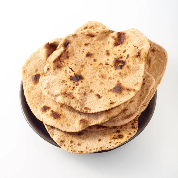 インドの小麦粉のフラットシャパティパンの閉じる上にトーストし 白い背景に丸いボウルに入れ — ストック写真