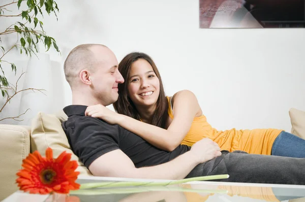 Jong Paar Ligt Camera Samen Glimlachend Bank Woonkamer — Stockfoto