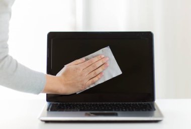 people, housework, electronics and housekeeping concept - close up of woman hand cleaning laptop computer screen with cloth clipart