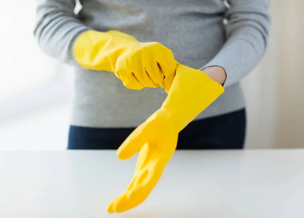 people, housework, safety and housekeeping concept - close up of woman hands wearing protective rubber gloves