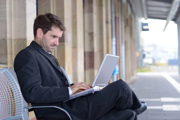 man in dark suit on business trip using computer