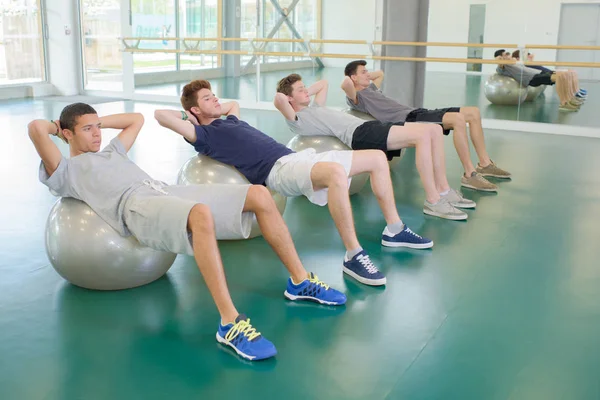 Quatro Homens Exercitando Bolas Aeróbicas — Fotografia de Stock