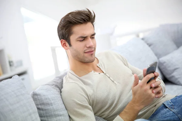 Mann Mit Smartphone Beim Lesen Von Nachrichten Skeptisch — Stockfoto