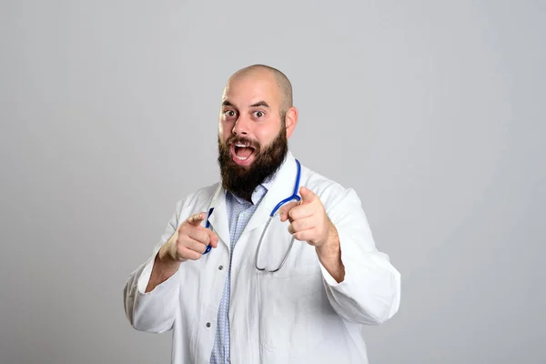 Young Bearded Doctor White Coat Smiling Pointing Camera — Stock Photo, Image