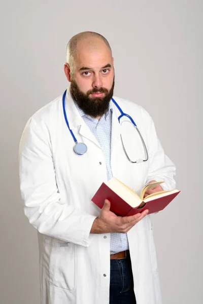 留着胡子的年轻医生 穿着白衣看书 — 图库照片