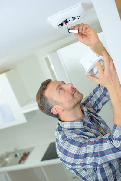 Safety conscious man fitting a fire smoke alarm