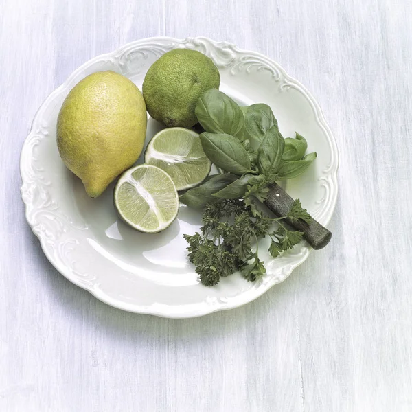 Zitronen Und Eine Halbierte Zitrone Mit Basilikum Und Petersilie Auf — Stockfoto