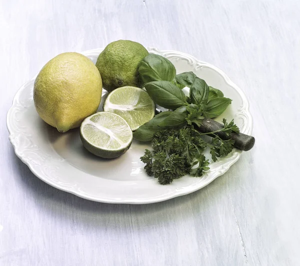 Zitronen Und Eine Halbierte Zitrone Mit Basilikum Und Petersilie Auf — Stockfoto