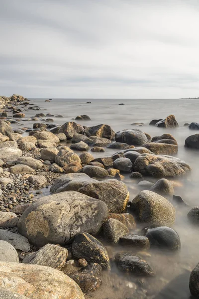 Rocky Shoreline Över Oceanen Med Delvis Grumlig Himmel — Stockfoto