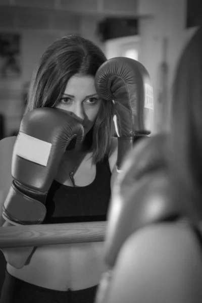young woman boxing tries to protect her face with her fists