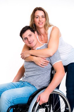 young disabled man in wheelchair and his wife clipart