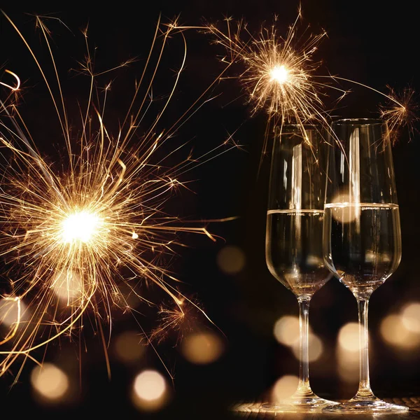 花火で夜の新年のモチーフボケとシャンパングラス2つ — ストック写真