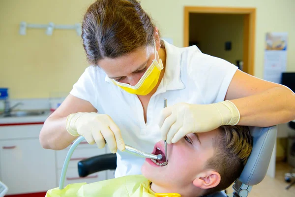 10代は歯科手術の女性歯科医によって治療され — ストック写真