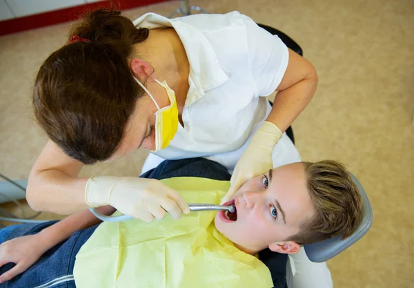 10代は歯科手術の女性歯科医によって治療され — ストック写真