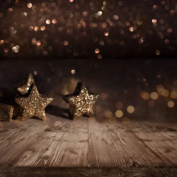 christmas background with stars glittering in front of gold shimmering lights