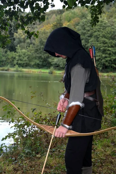 Joven Arquero Medieval Con Capucha Negra Levanta Con Arco Tenso —  Fotos de Stock