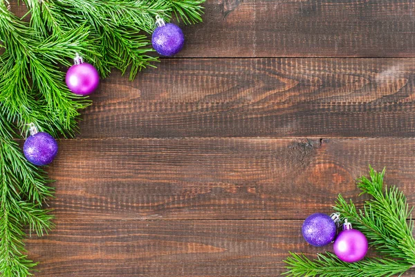 暗い板の背景に装飾が施されたクリスマスモミの木 クリスマスツリーと紫色の泡とボーダーアートデザイン コピースペースとクリスマスと新年のコンセプト — ストック写真