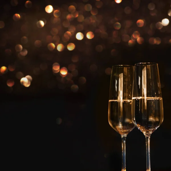 champagne for a festive occasion against a dark background with gold shimmering light and bokeh