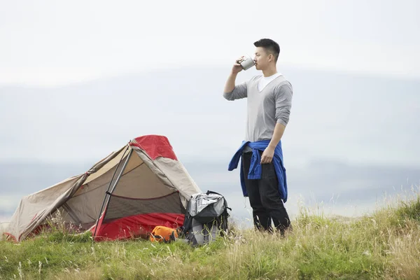 Young Man On Camping Trip In Countryside