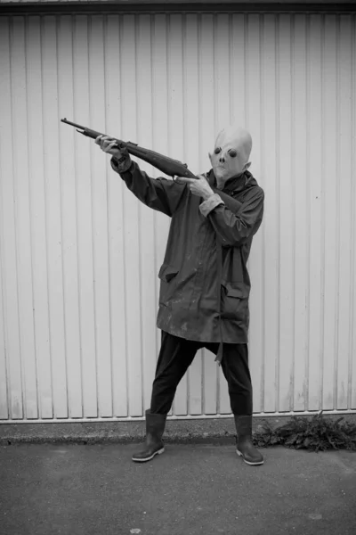 앞에서 산탄총으로 사냥하는 외계인 마스크를 — 스톡 사진
