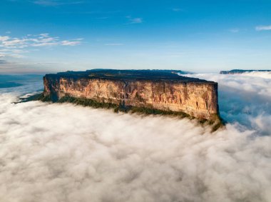 The magnificent Mount Roraima towers above the clouds hanging over the Gran Sabana in Venezuela clipart