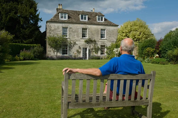 Older man sitting in backyard
