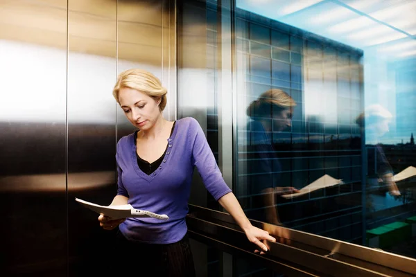 Женщина Лифте Читает Файл — стоковое фото