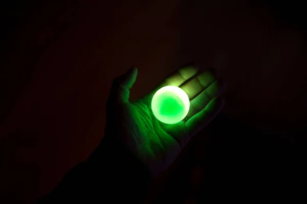 ライトアップされた緑の玉を持つ者 — ストック写真