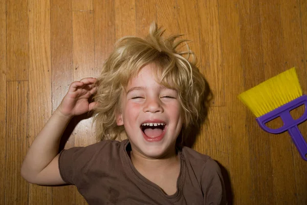 Menino Deitado Chão Madeira Rindo — Fotografia de Stock